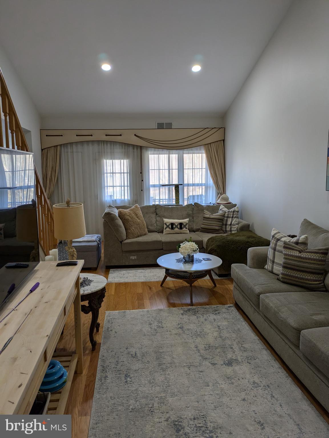 a living room with furniture a window and a flat screen tv