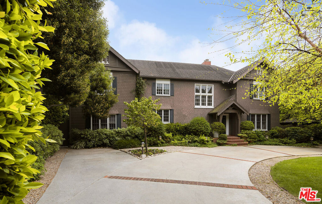 a front view of a house with a yard and potted plants