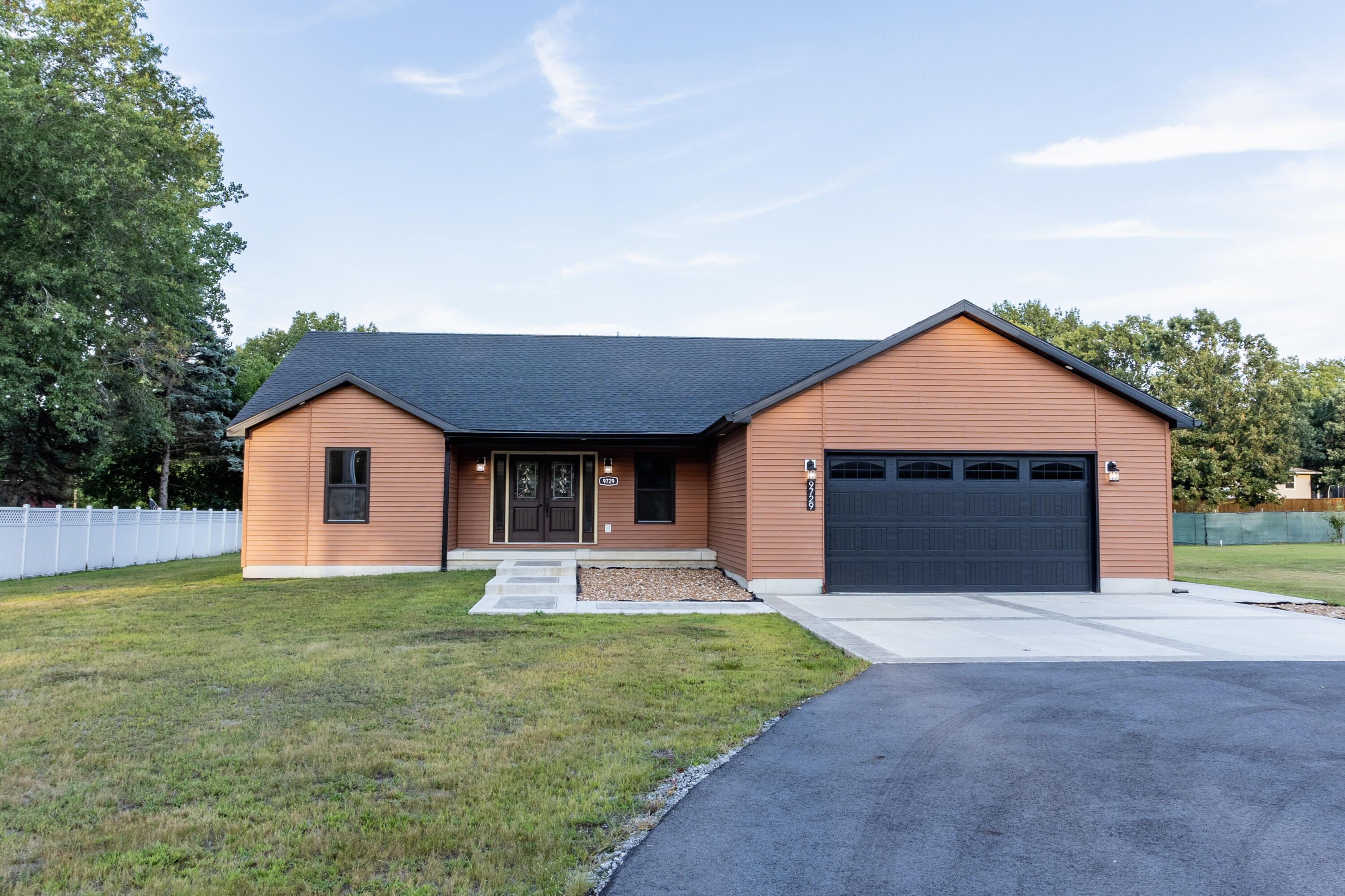 a front view of house with yard and garage