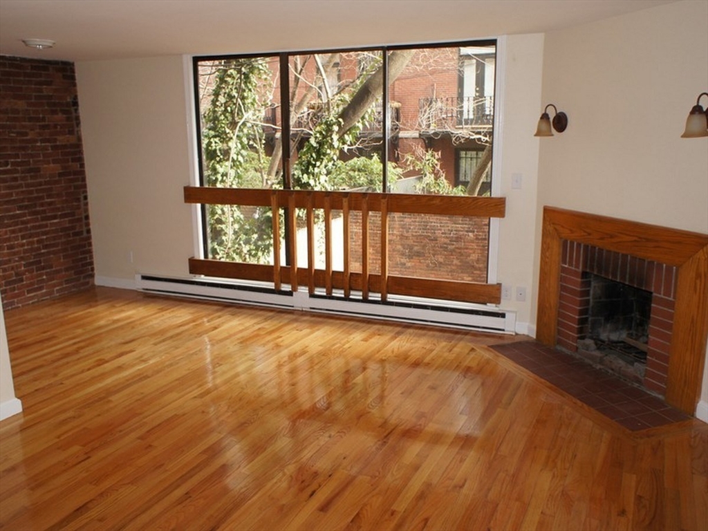 a view of an empty room with a fireplace and a window