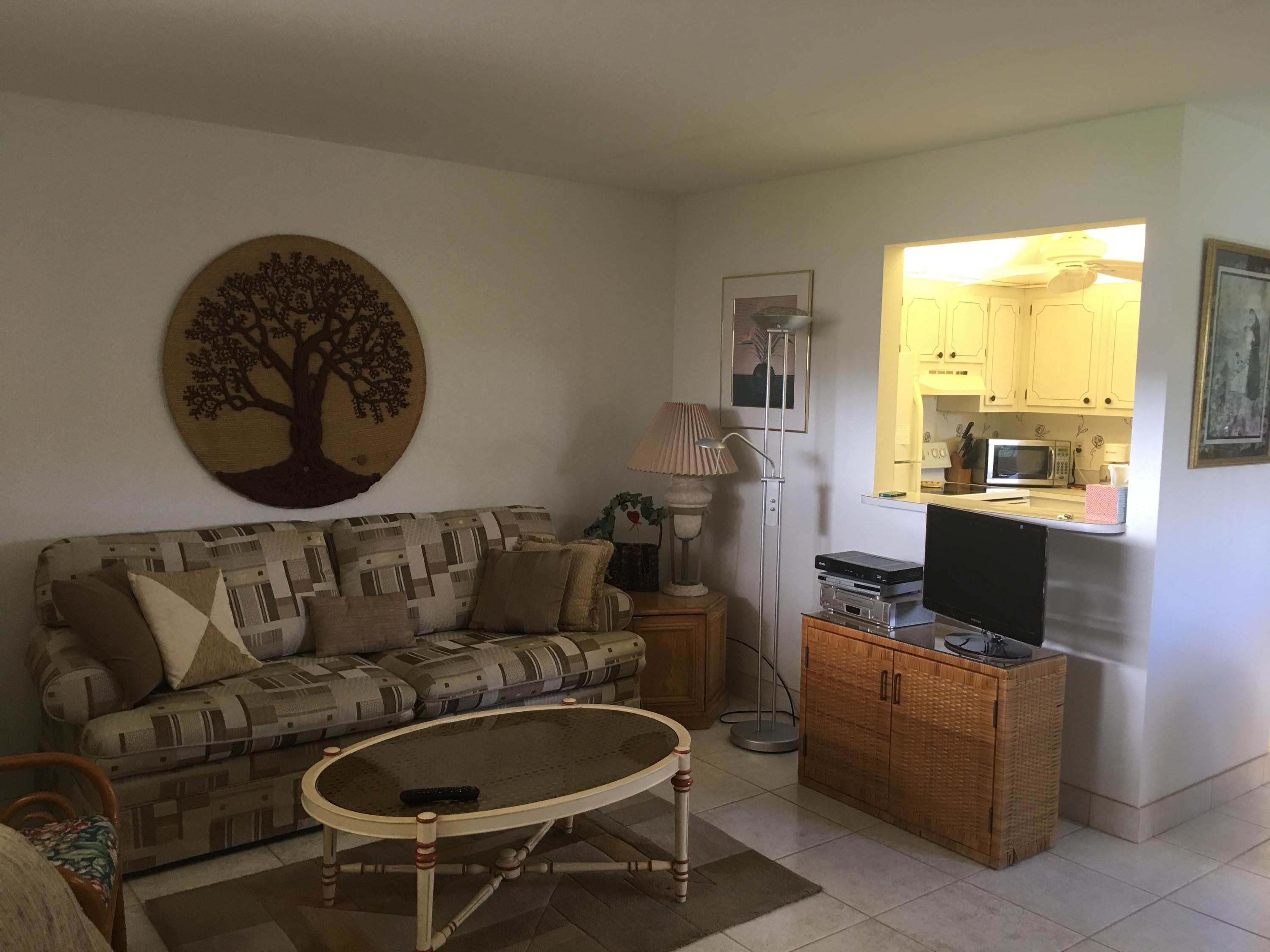 a living room with furniture a flat screen tv and a floor to ceiling window