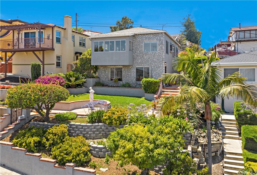 a view of a house with swimming pool lawn chairs and a flower plants