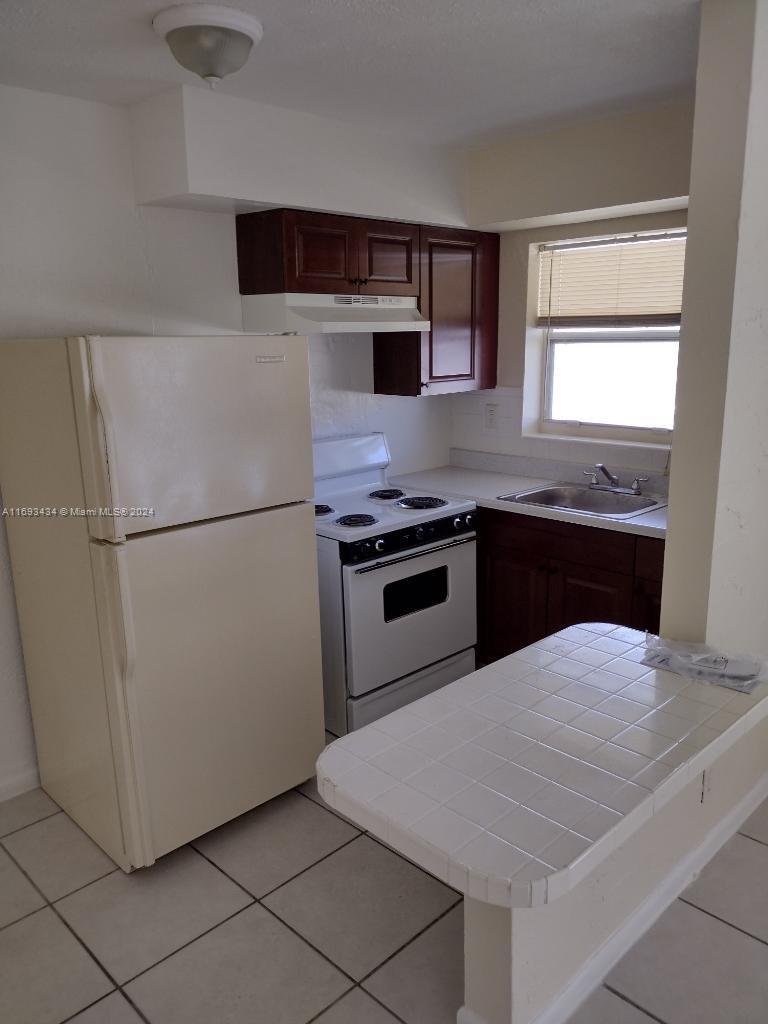 a kitchen with stainless steel appliances granite countertop a refrigerator sink stove and microwave