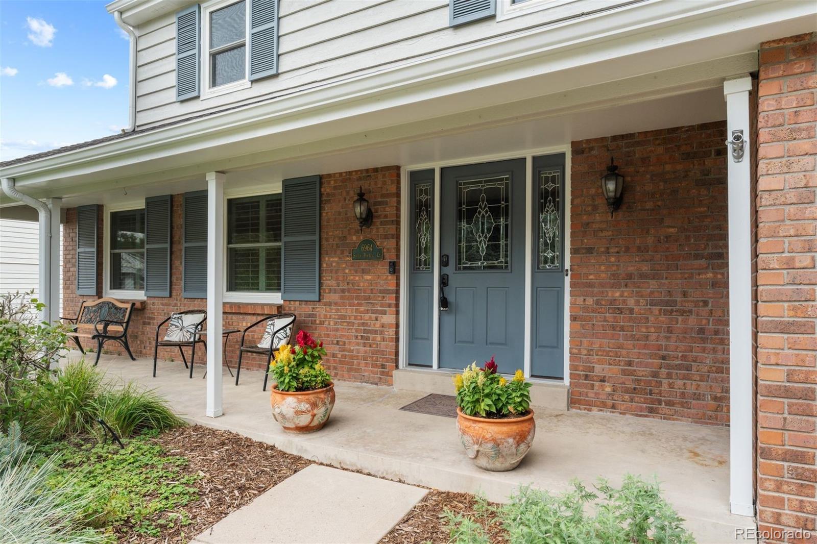 a front view of a house with outdoor seating and a potted plant