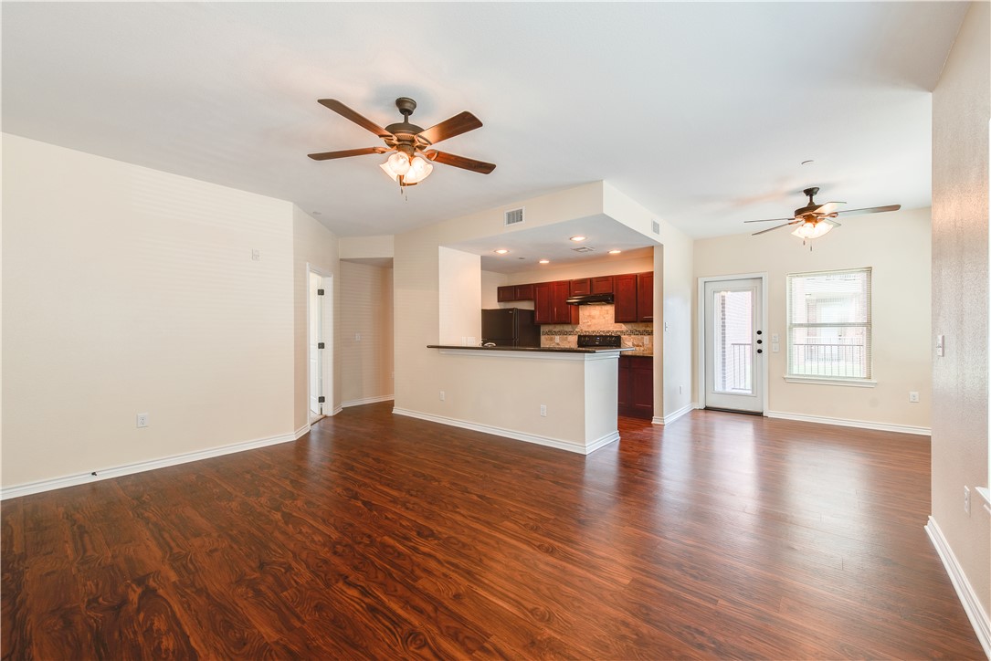 Unfurnished living room featuring ceiling fan and