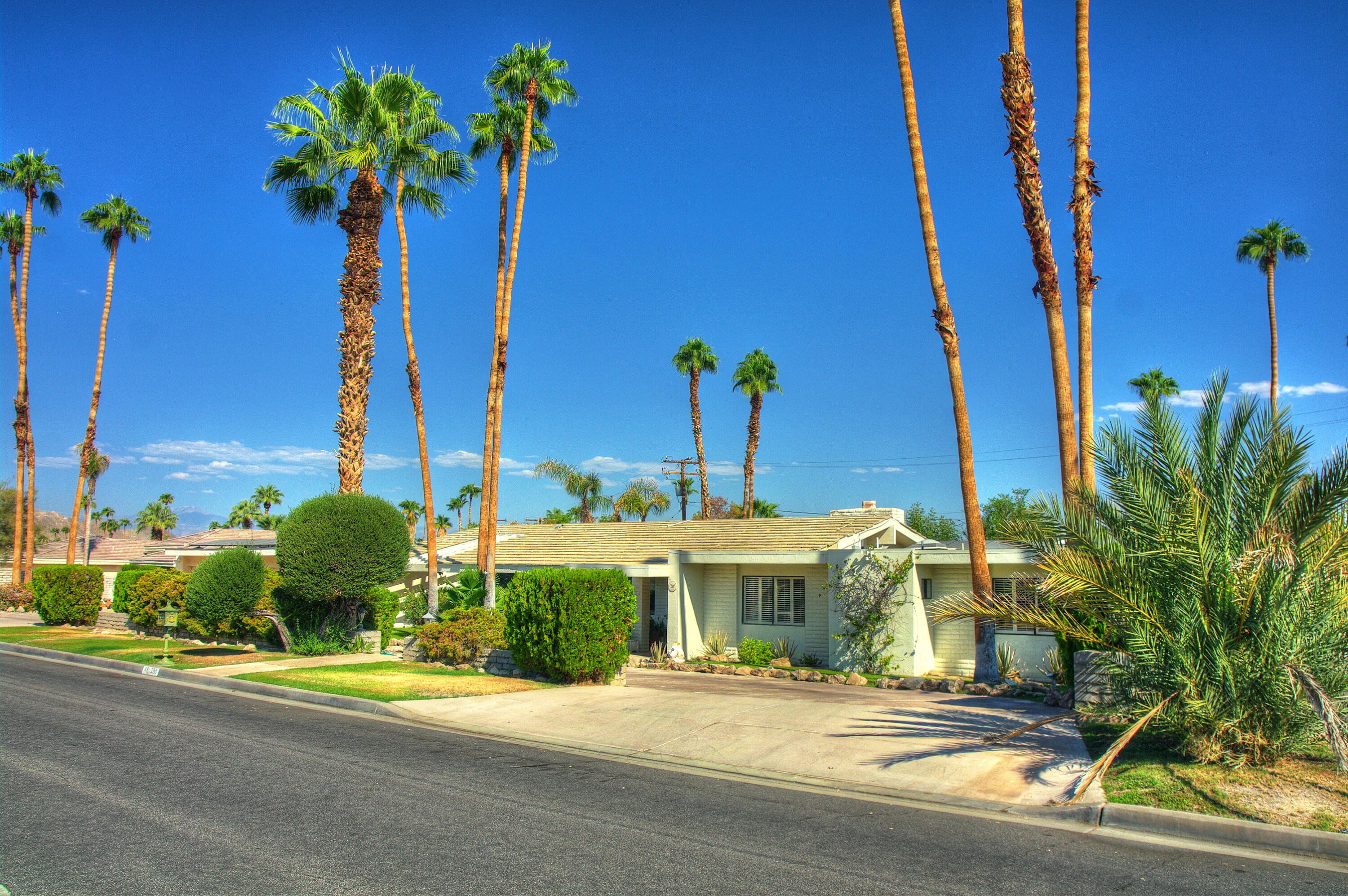 a front view of a house with a yard and potted plants