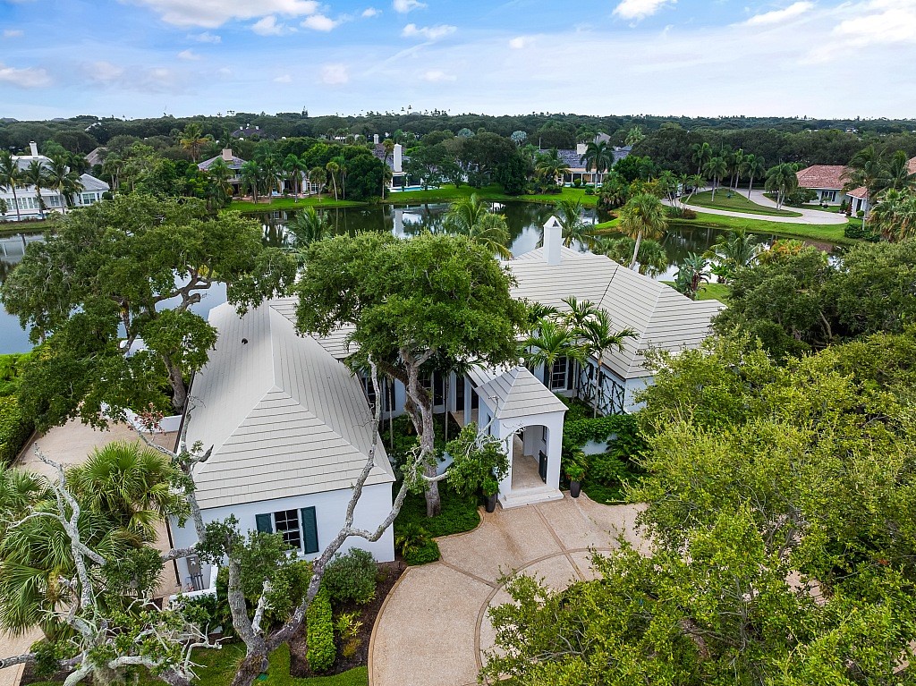 an aerial view of a house with a yard and lake view