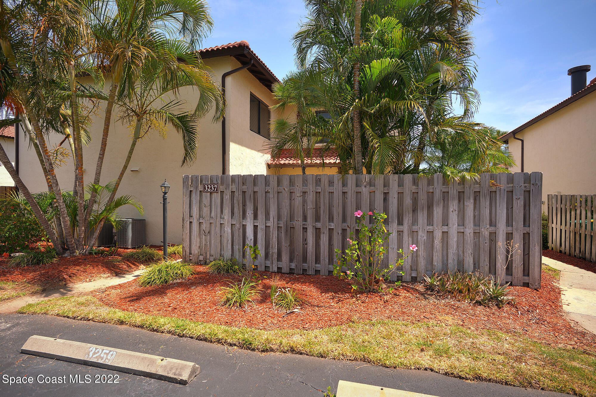 a view of a brick house with a small backyard