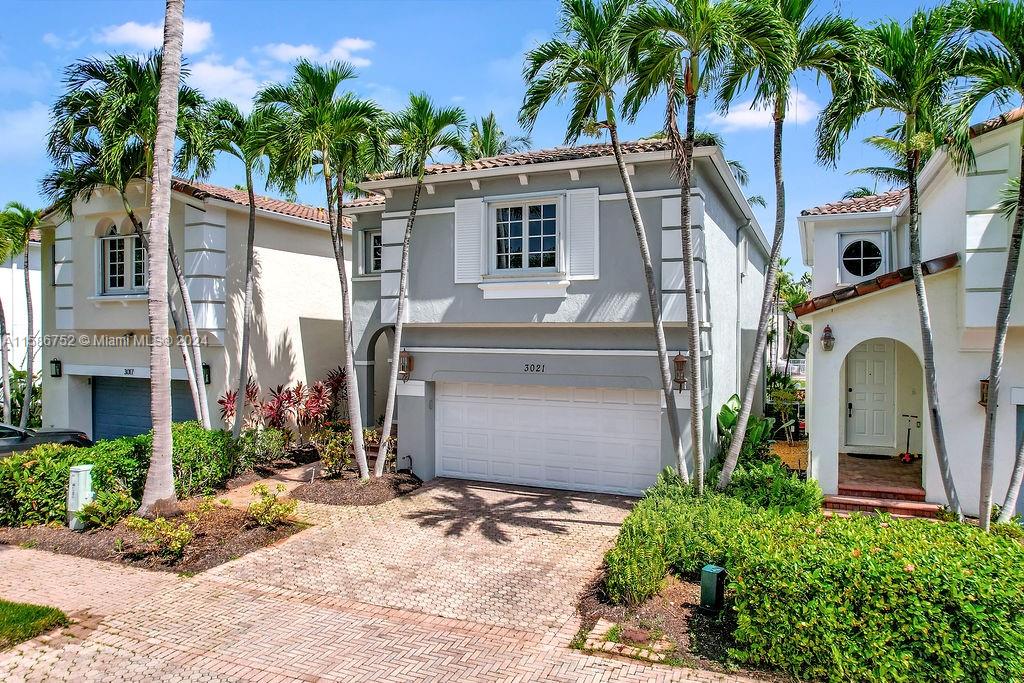 a front view of a house with a yard and potted plants