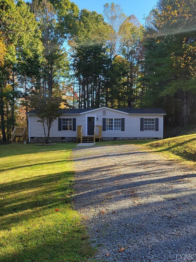 a view of a house with a big yard and large trees