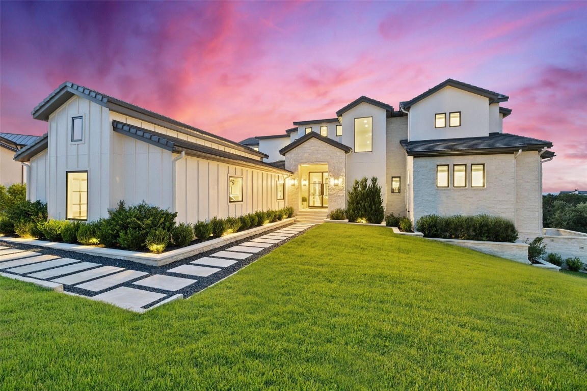 a front view of a house with yard and green space