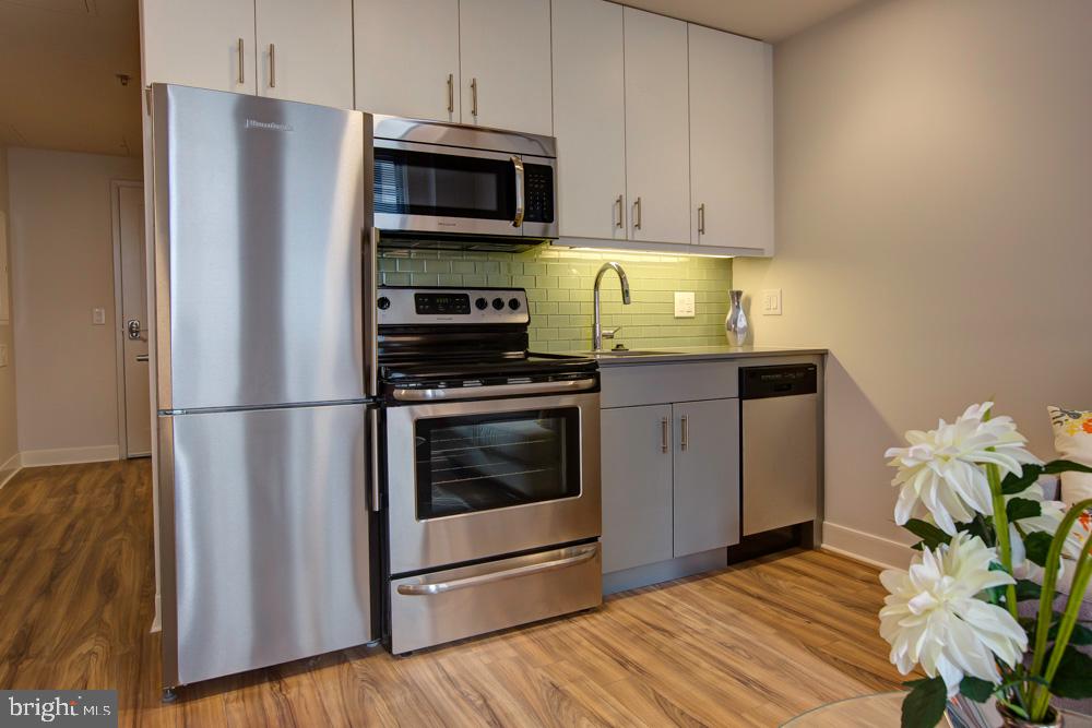 a kitchen with stainless steel appliances a stove a microwave and a refrigerator