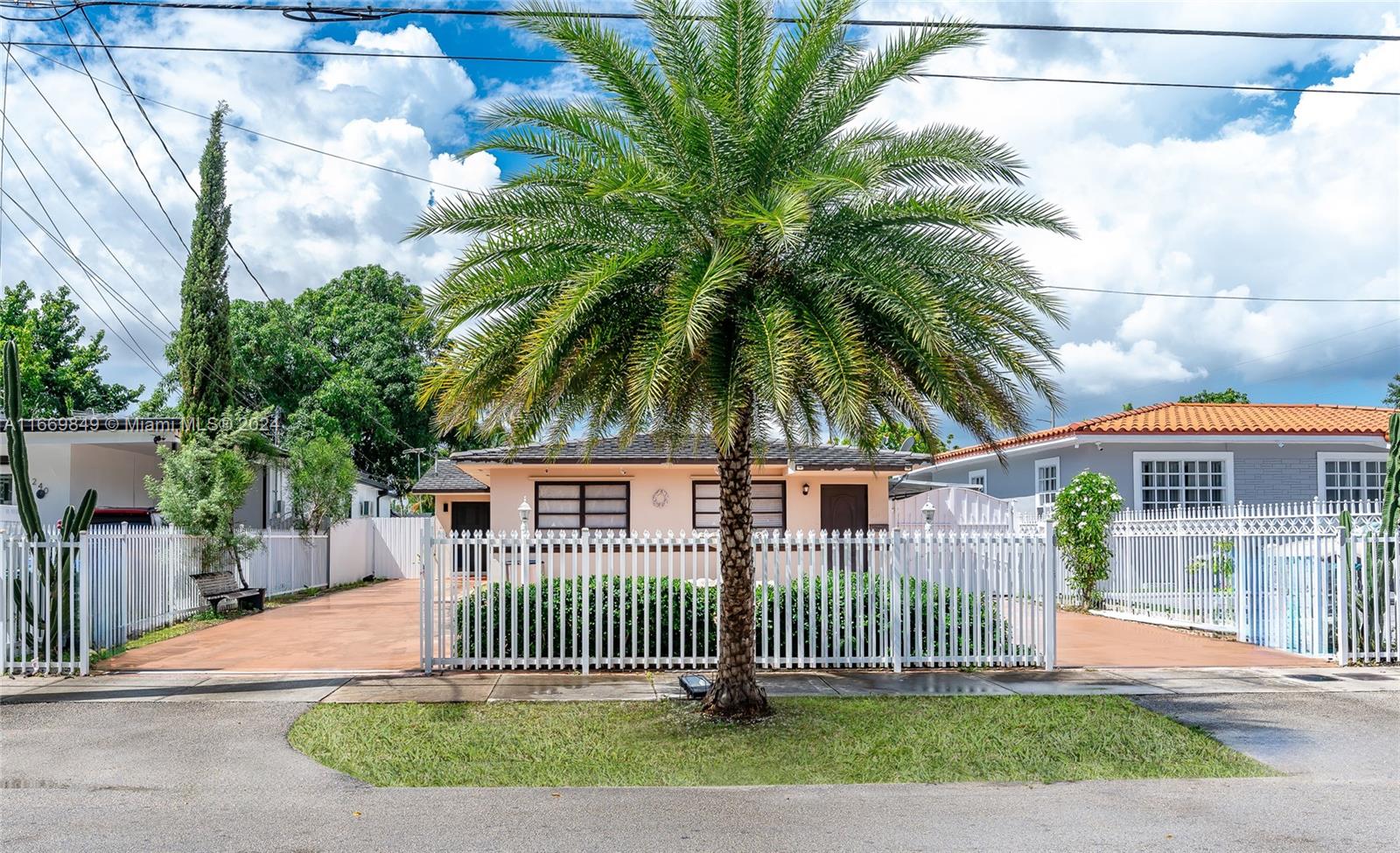 a front view of a house with a garden and plants