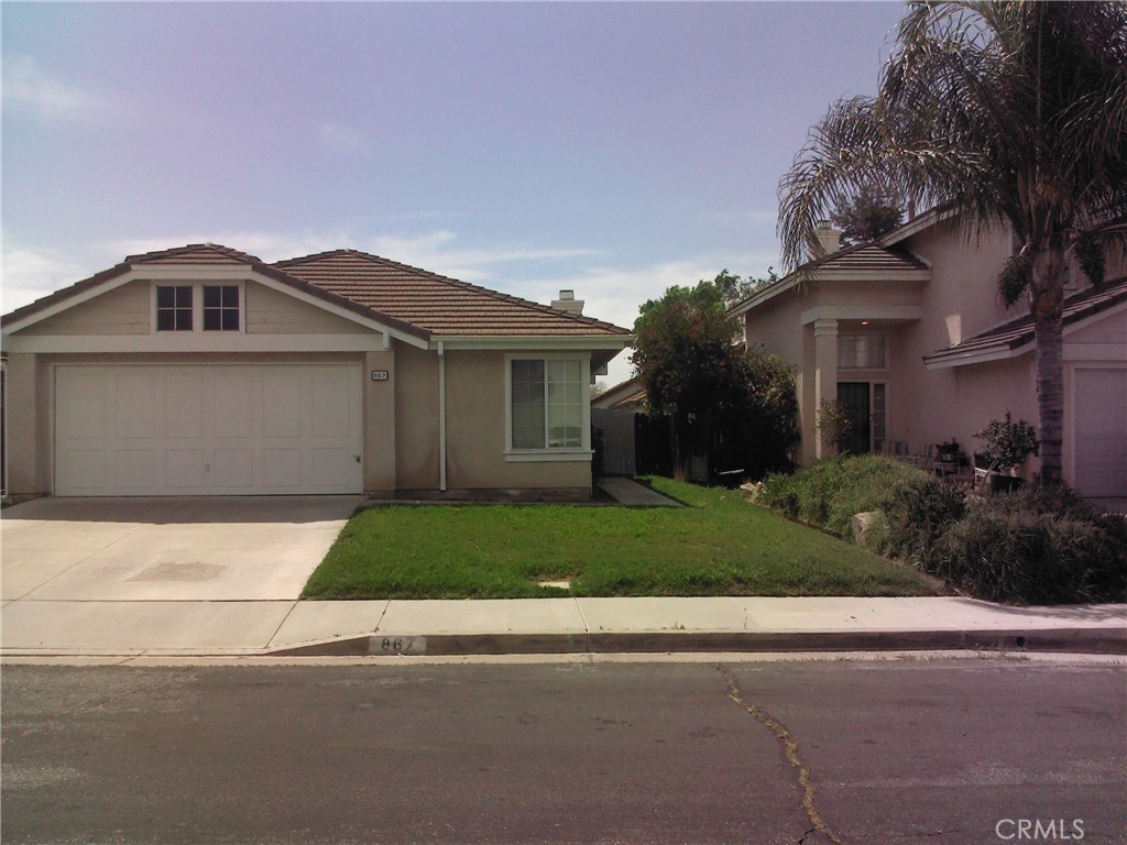 a front view of a house with a garden and trees