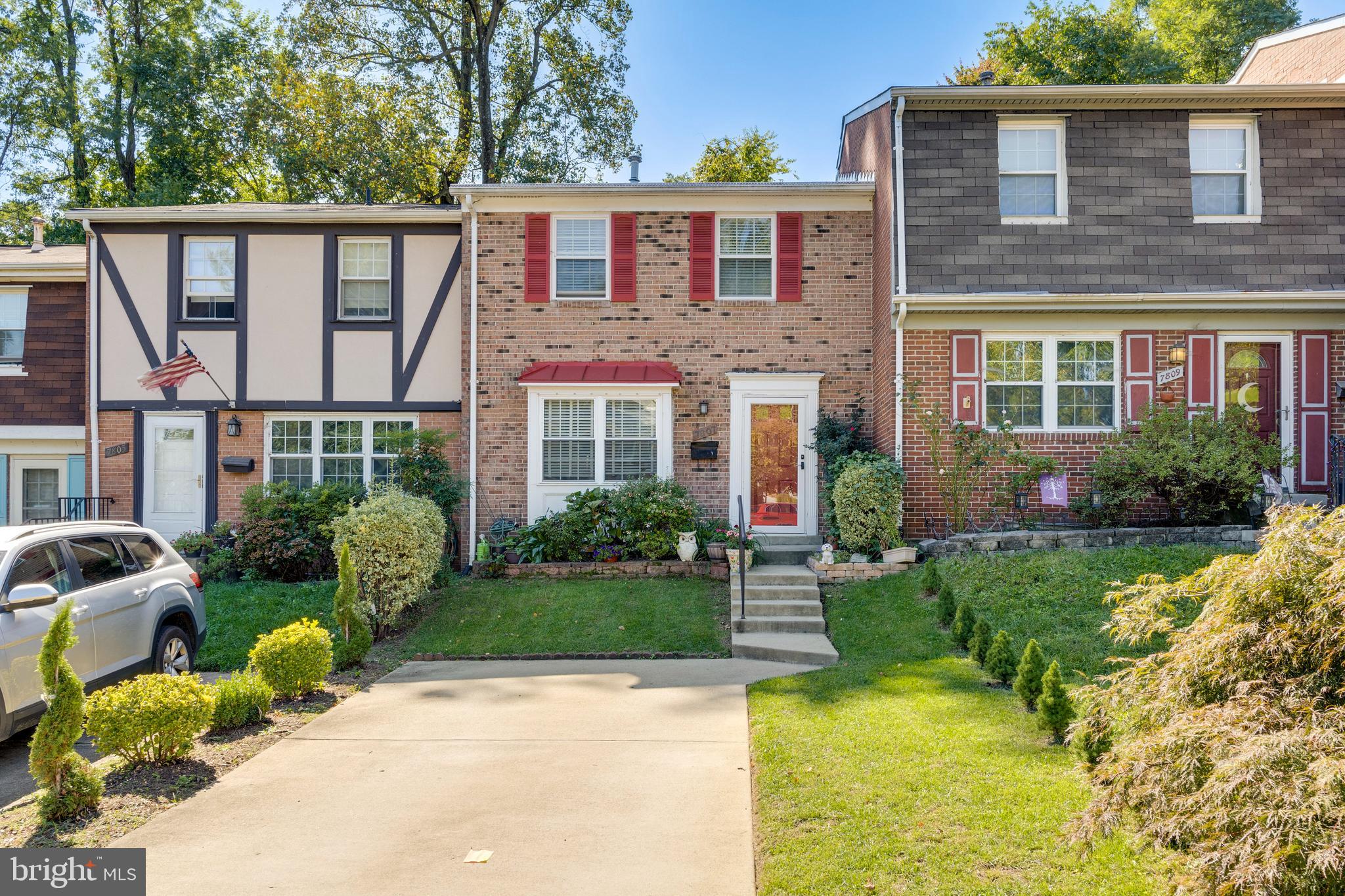 a view of a brick house with a yard and plants