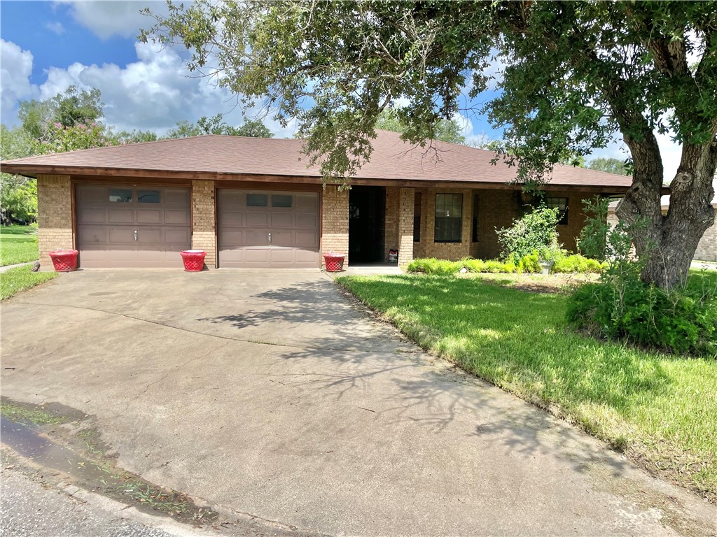 a front view of a house with a yard and a garage