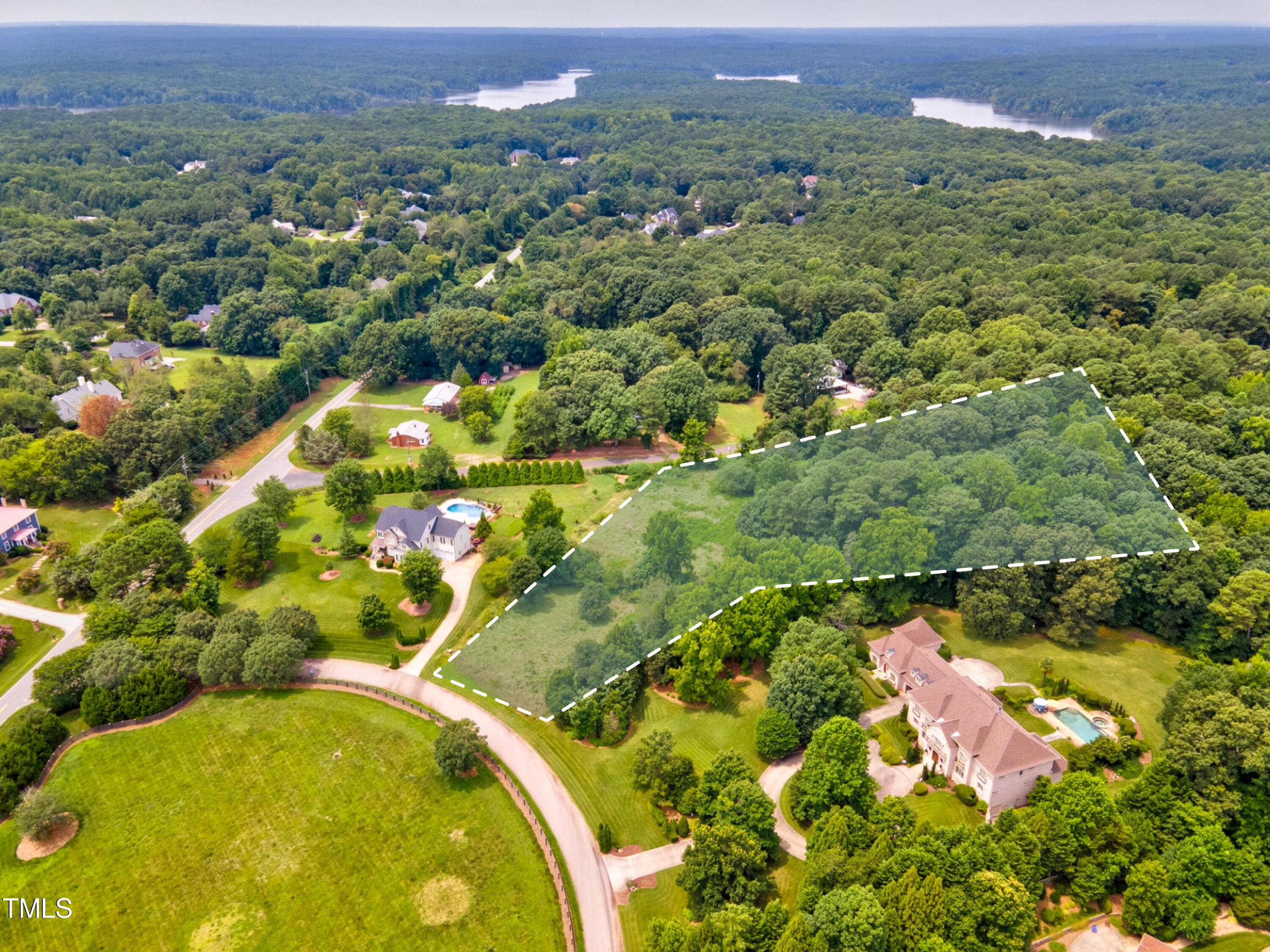 an aerial view of residential houses with outdoor space and trees