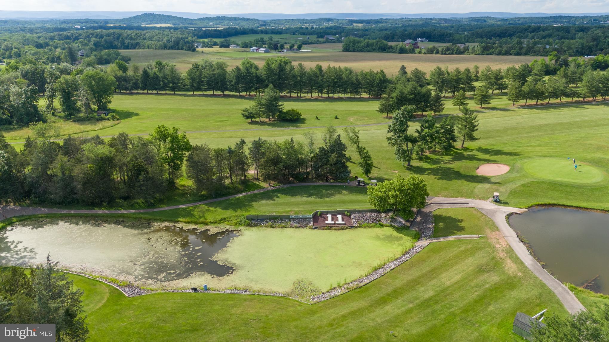 an aerial view of a golf course with a lake view