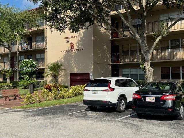 a view of a cars park in front of a building