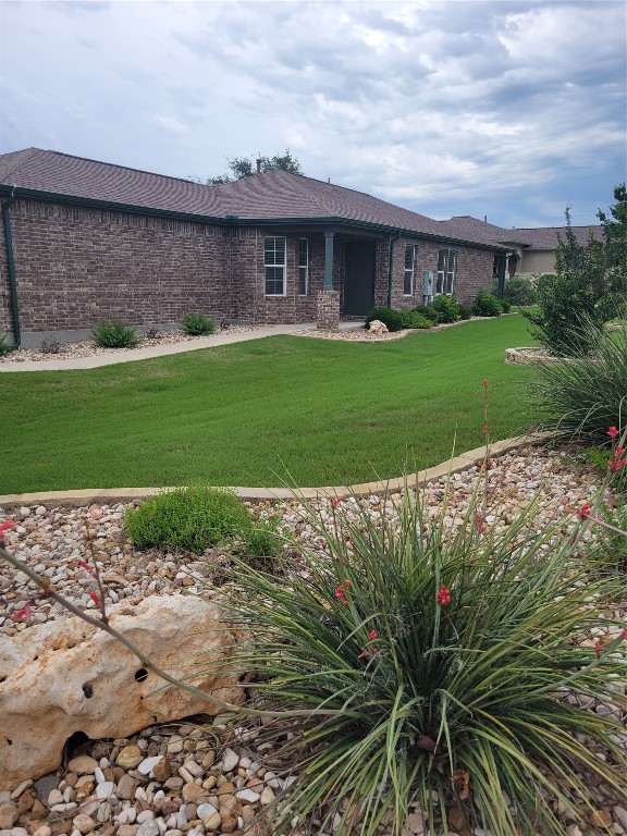 a front view of a house with a yard and potted plants