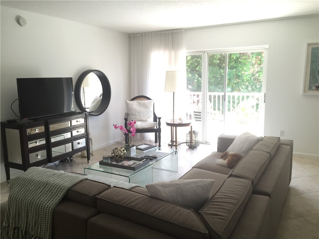 a living room with furniture a flat screen tv and a large window