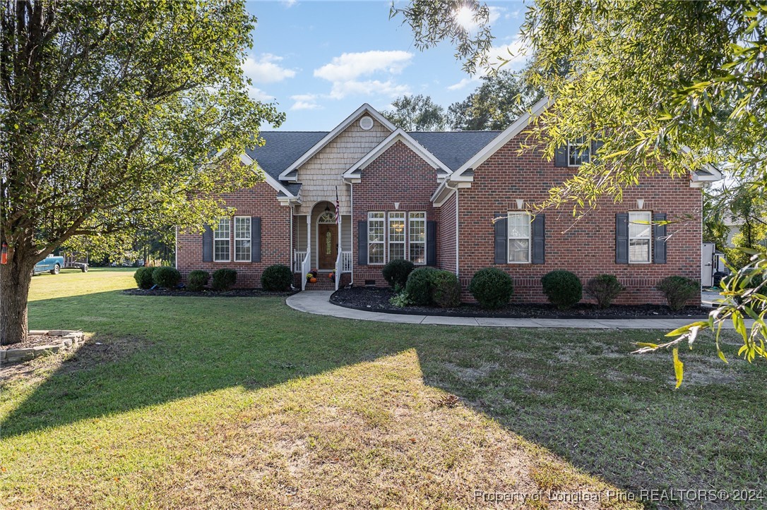 a front view of a house with a yard and trees