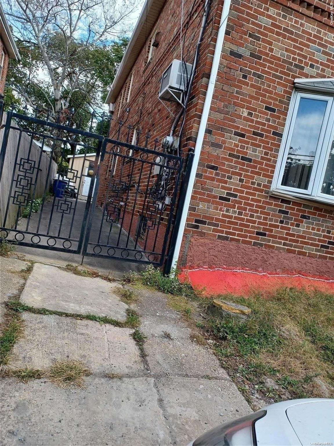 a view of brick wall of building and tree in front of it