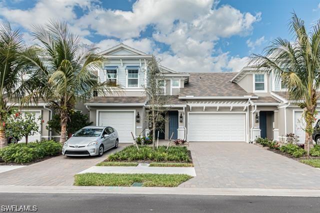 a front view of a house with a garden and garage