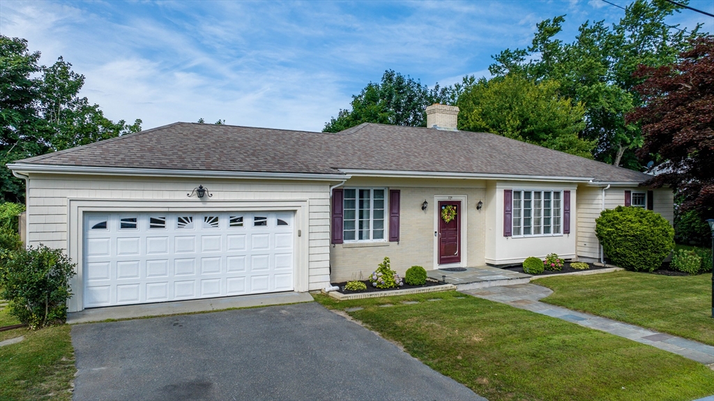 a front view of a house with a garden and yard