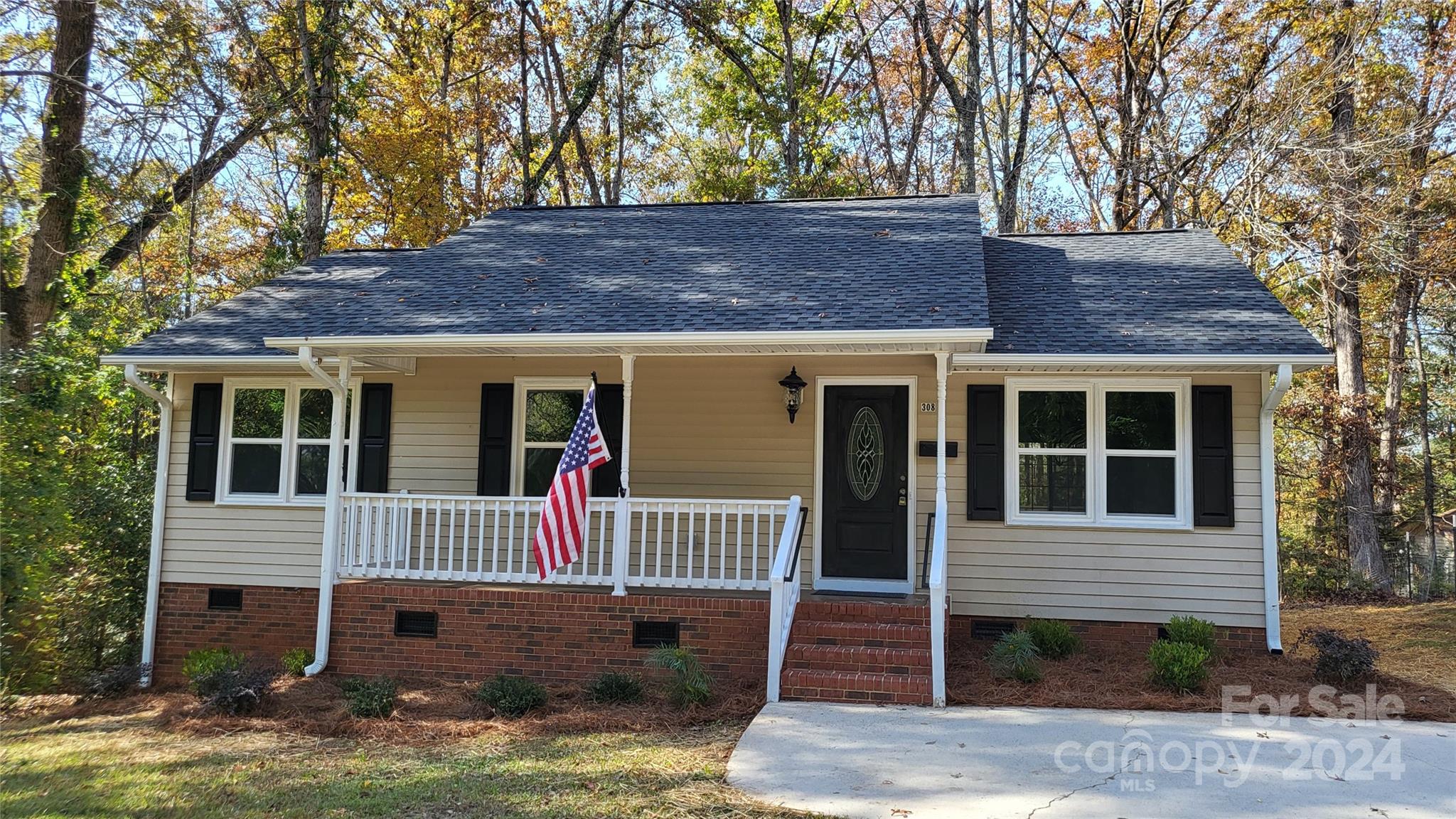 a view of a house with a tree in front of it