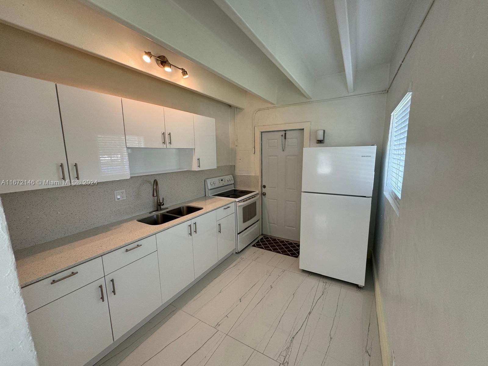 a kitchen with a refrigerator sink and cabinets