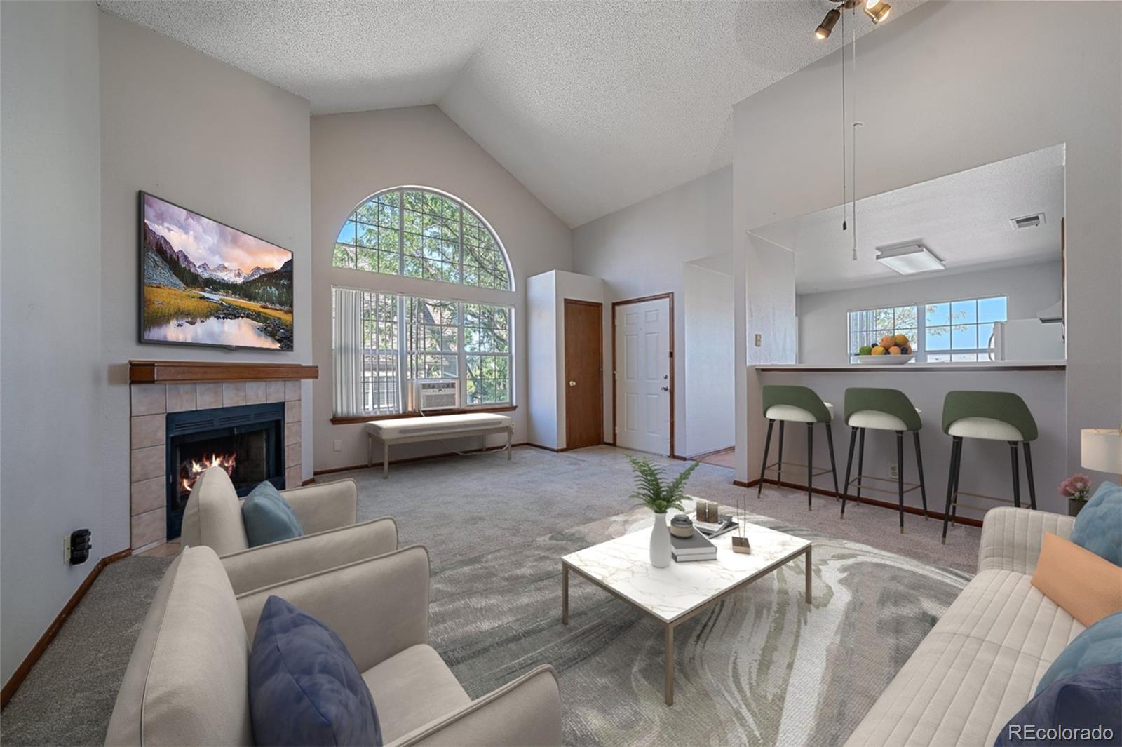 a living room with furniture a fireplace and a large window