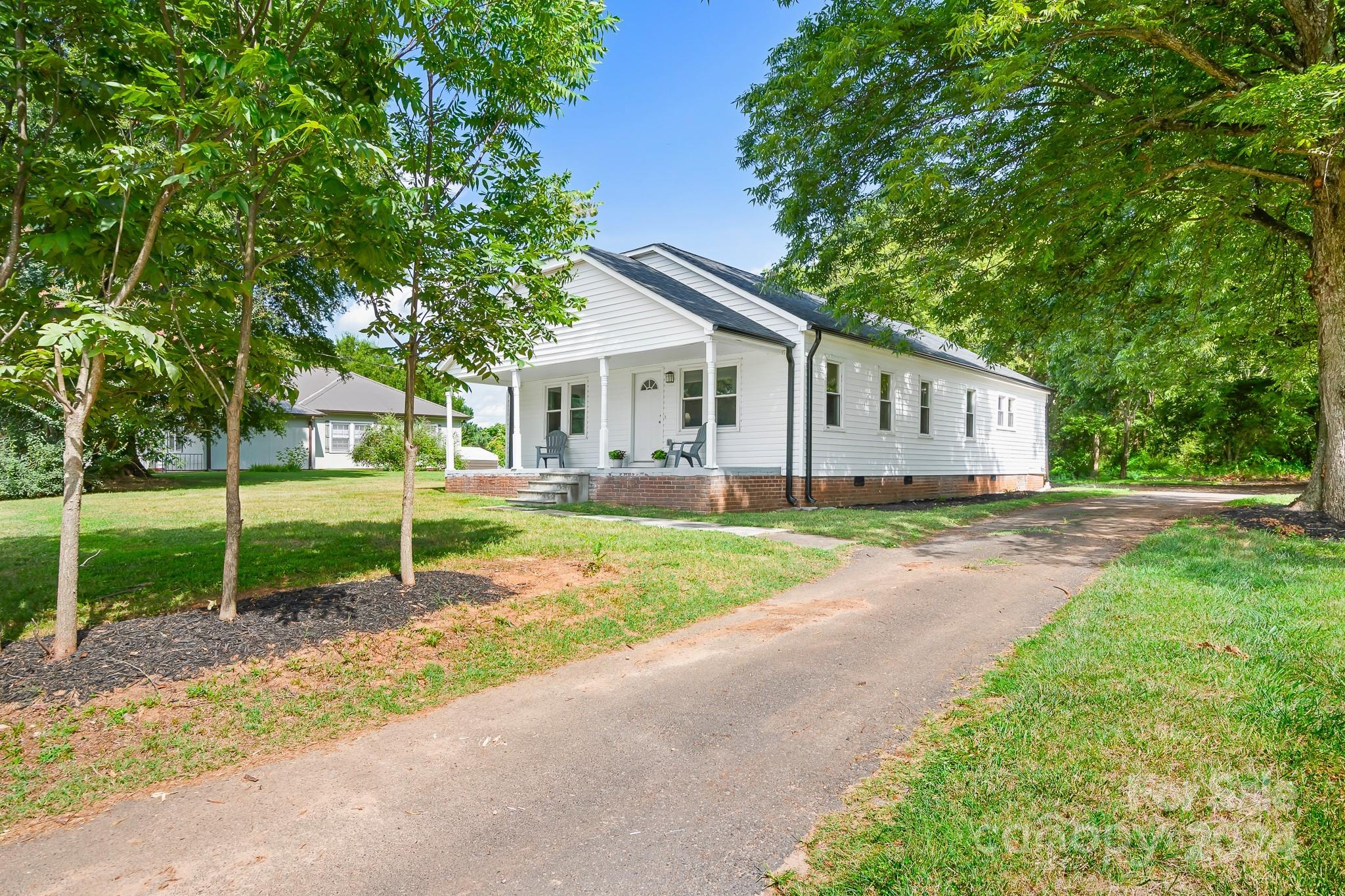 a view of house with a garden and trees