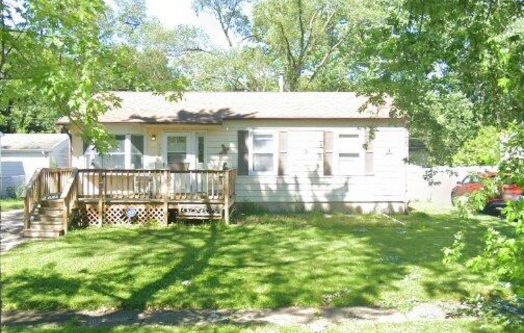 a view of a house with backyard and a patio