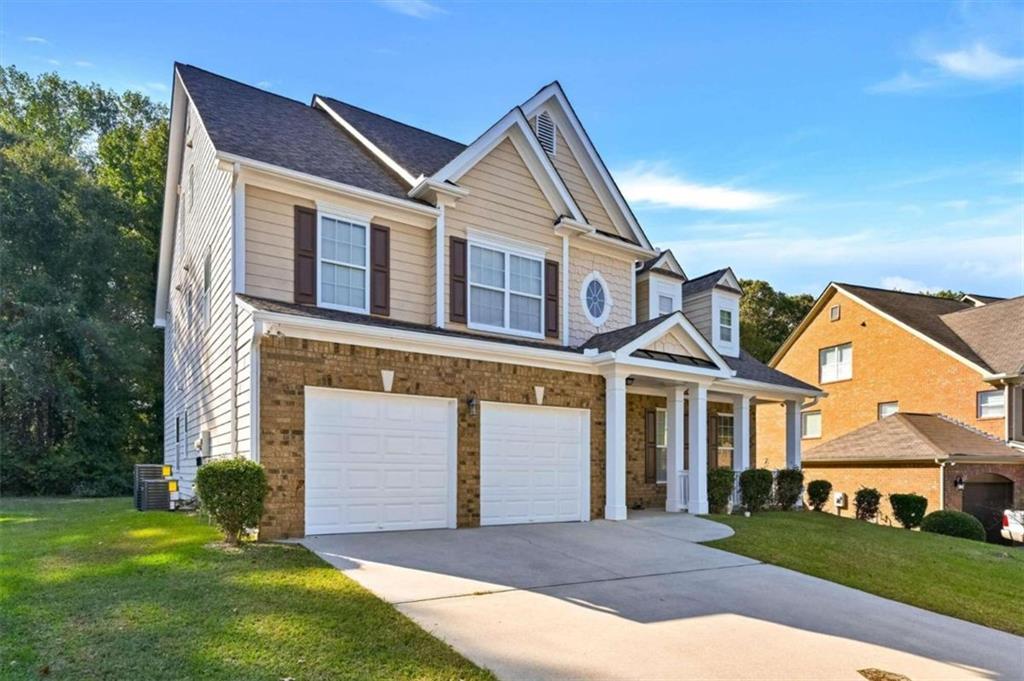 a front view of a house with a yard and garage