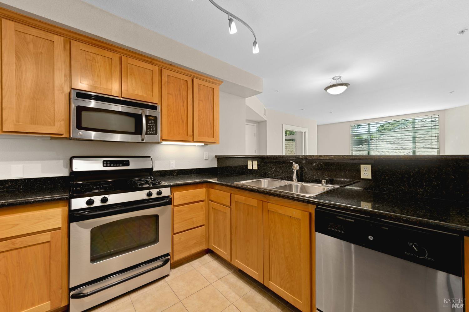 a kitchen with stainless steel appliances a stove sink microwave and cabinets