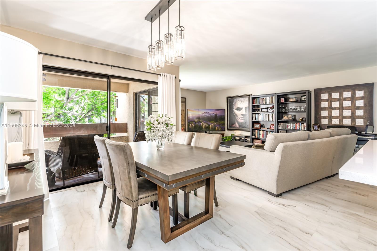 a living room with furniture a chandelier and a large window