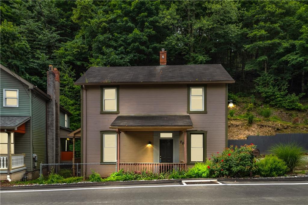 a front view of a house with a garden