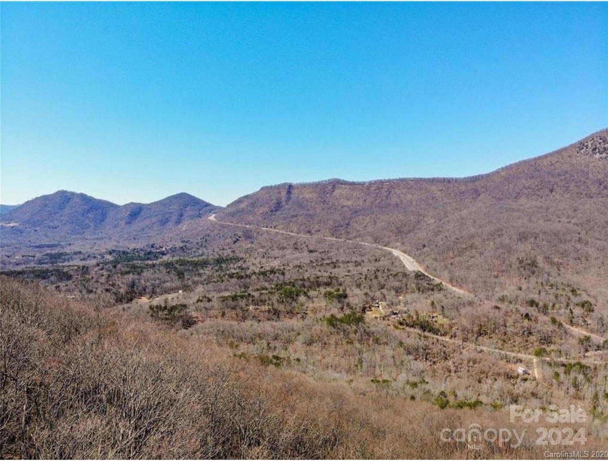 a view of a dry yard with mountains in the background