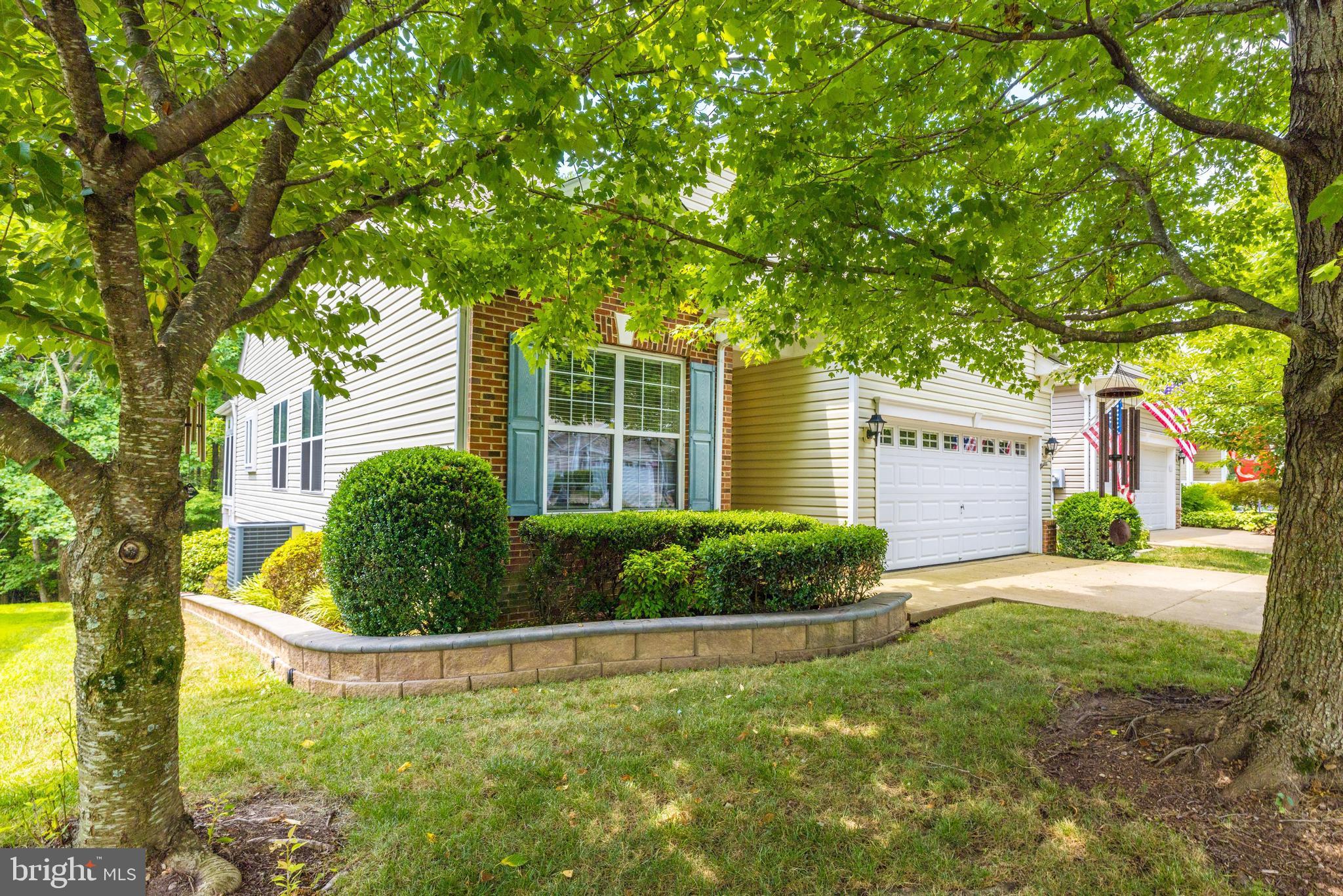 a view of a house with a yard and large tree