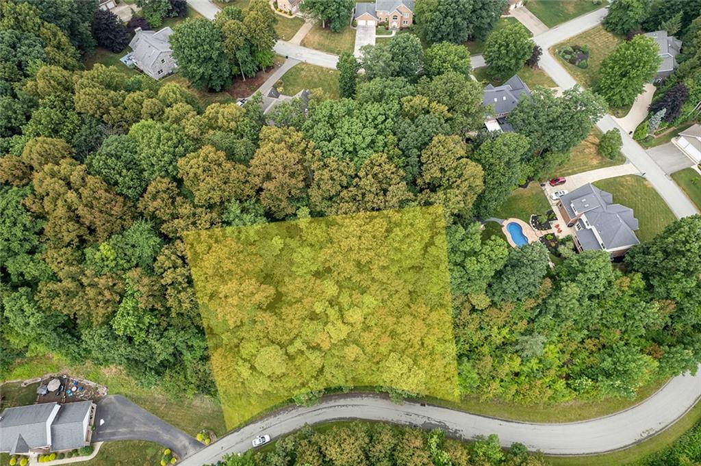 an aerial view of residential house with outdoor space and trees all around