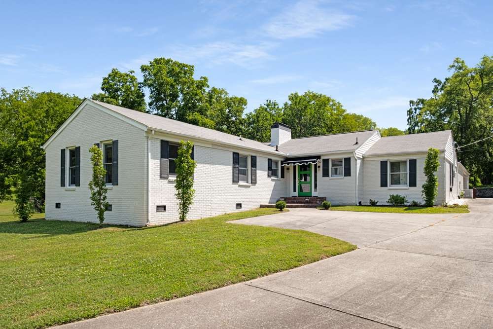 a front view of house with a garden and trees