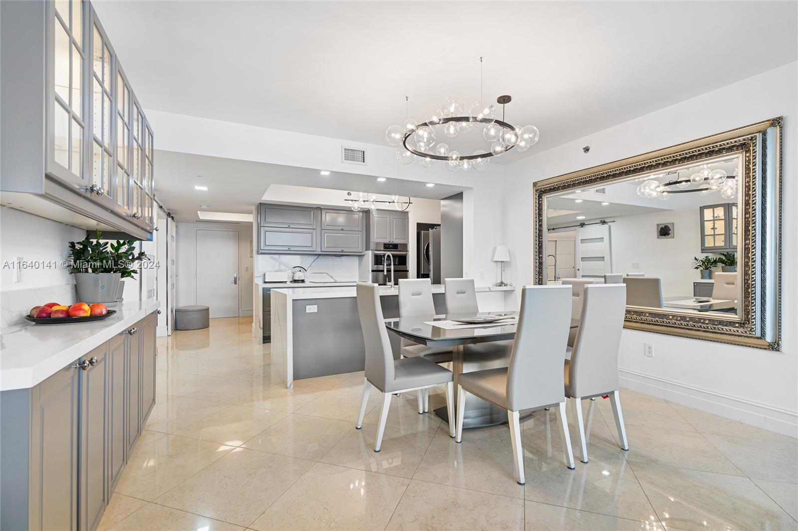 a kitchen with stainless steel appliances a dining table chairs stove and cabinets