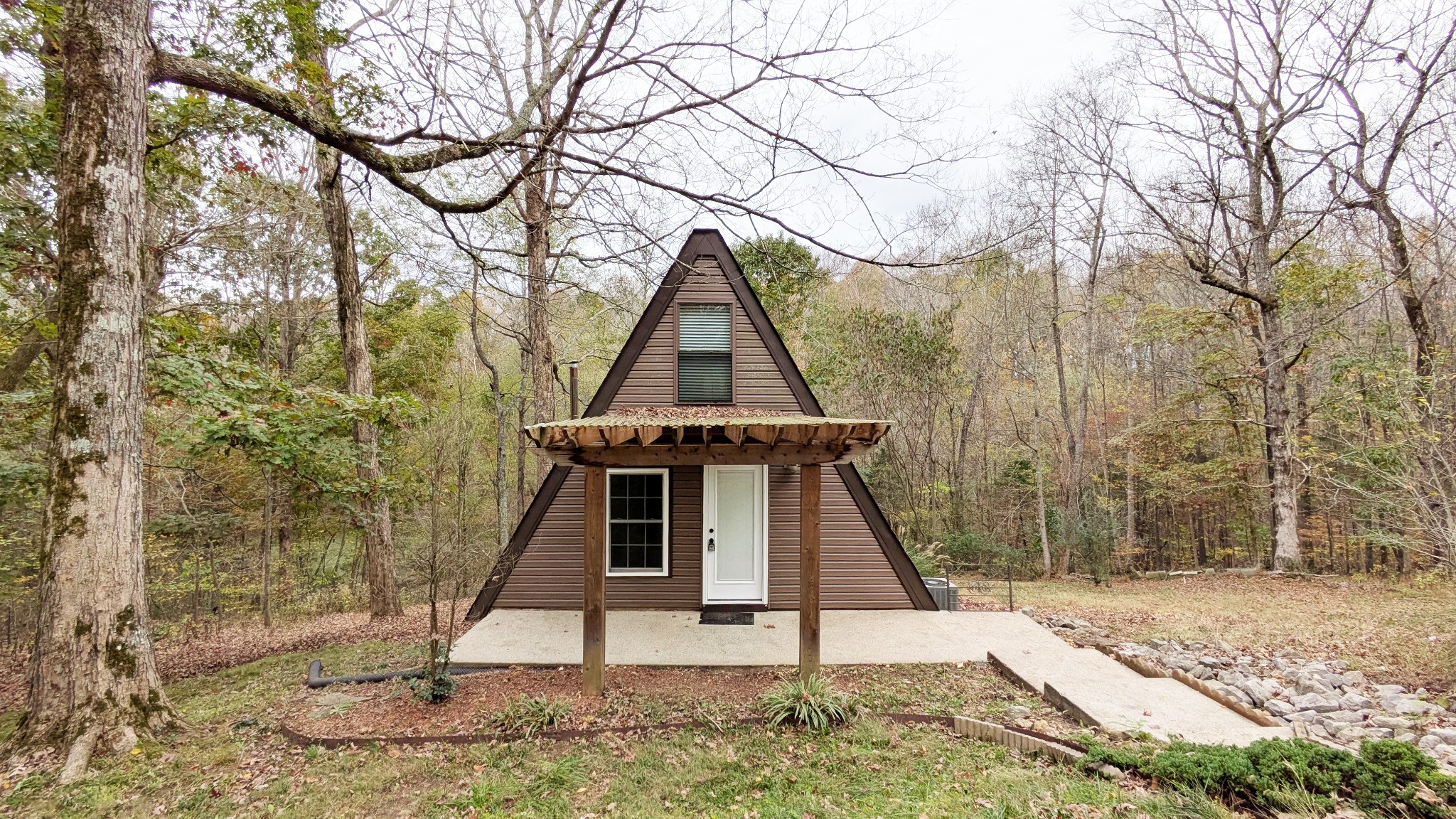 a wooden house with a tree in the background