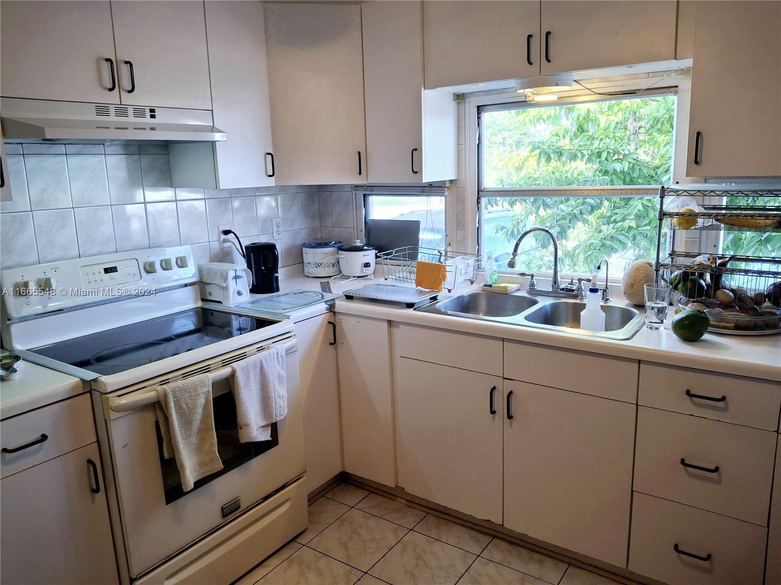 a kitchen with cabinets appliances a sink and a window