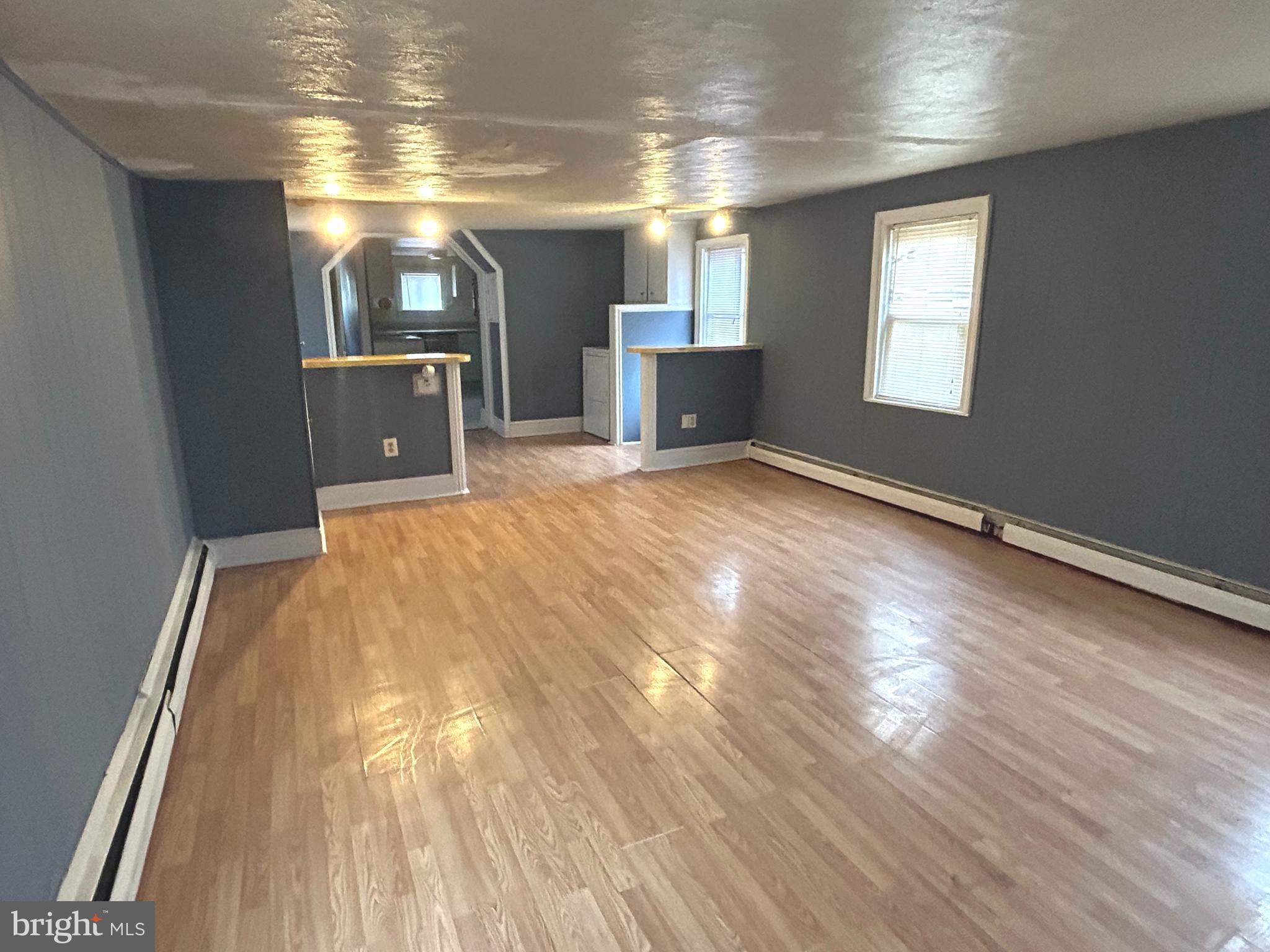 a view of empty room with wooden floor