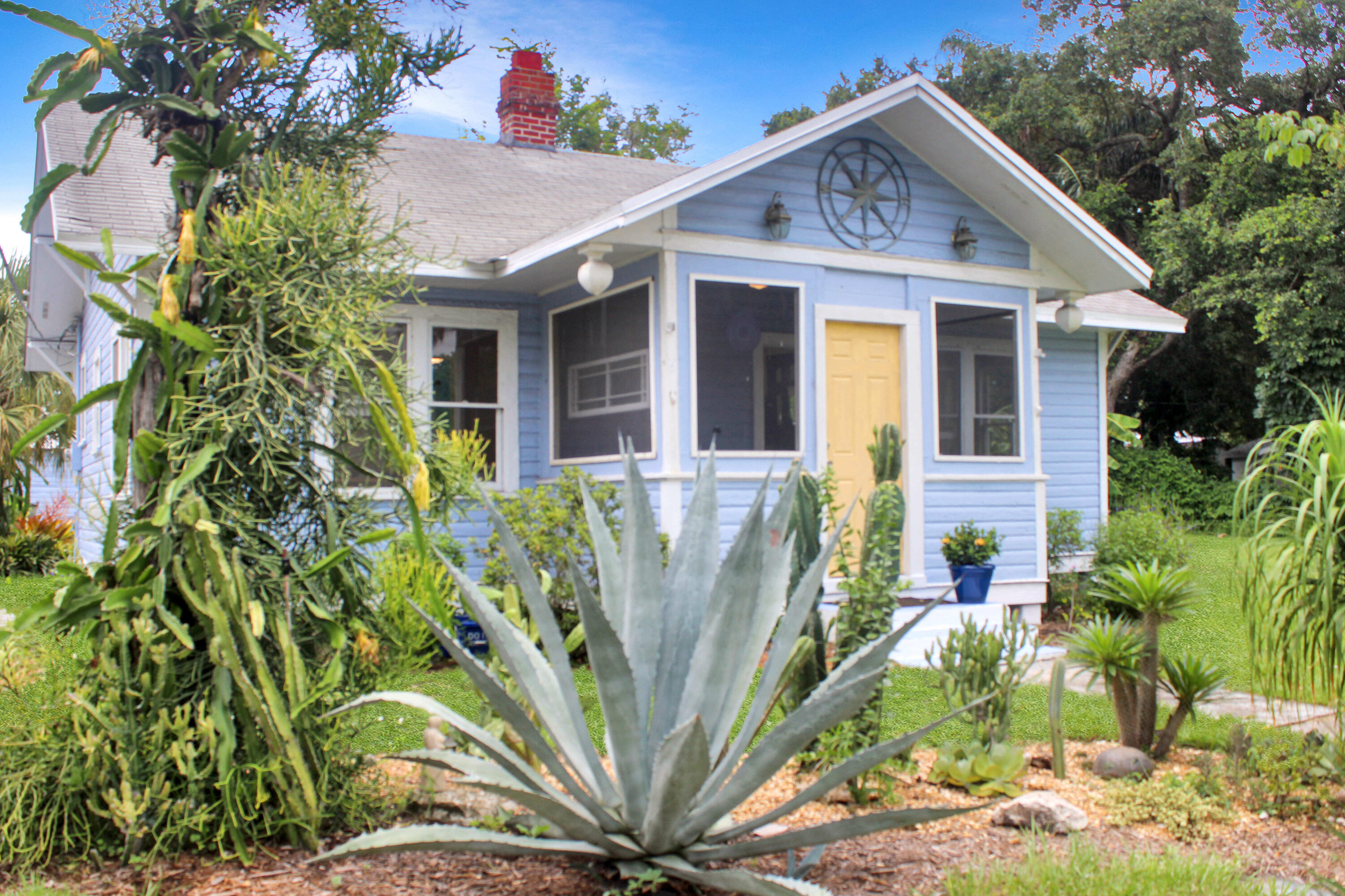 a view of a white house with a small yard and plants