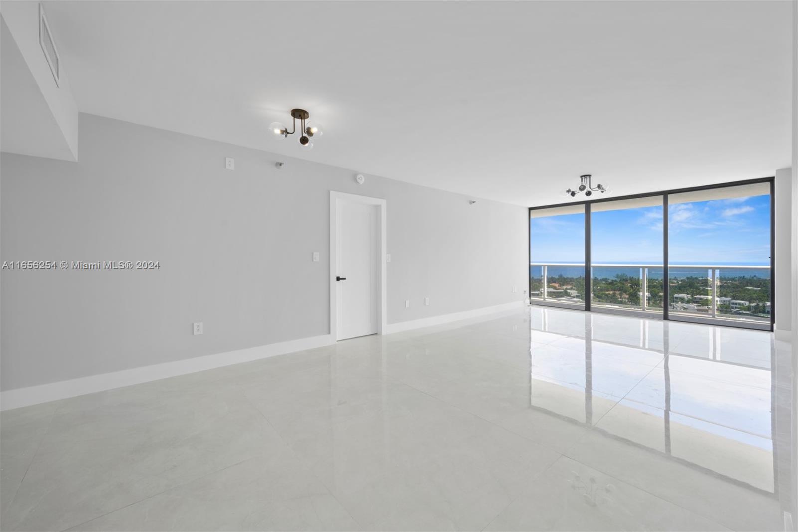 an empty room with sliding glass door and shower