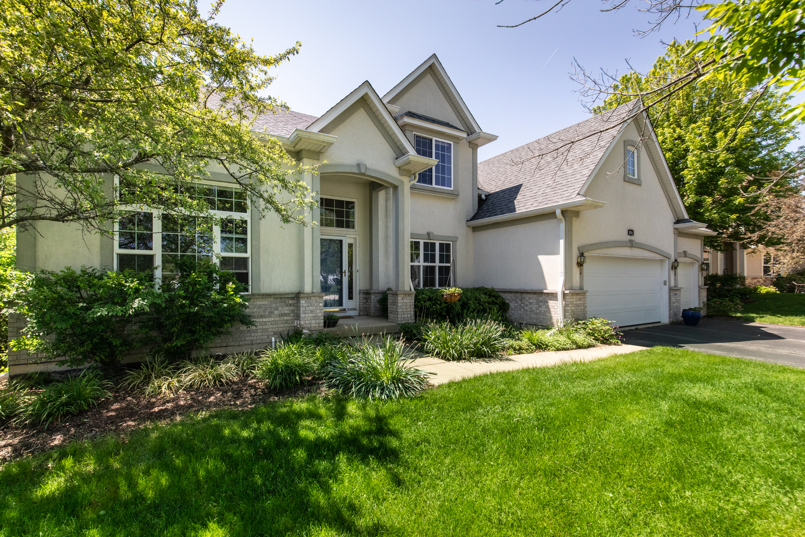 a front view of a house with a yard and trees