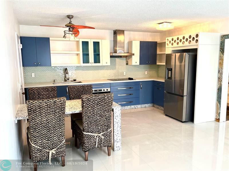 a kitchen with granite countertop cabinets and refrigerator